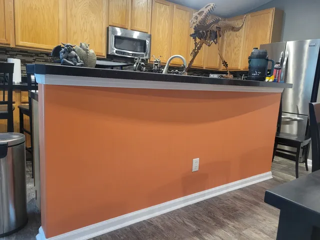 A freshly painted burnt-orange kitchen island in a Jacksonville home