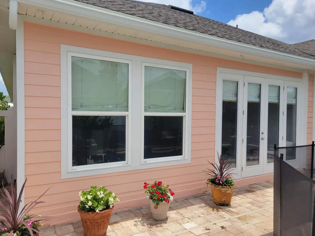 The same wall repainted in fresh coral with bright white window and door trim