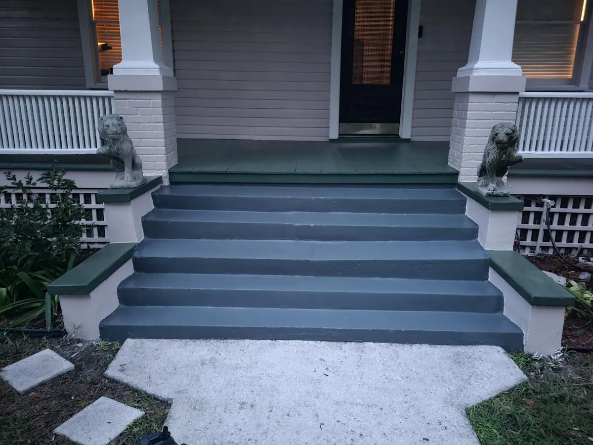 The same porch steps finished in smooth slate gray with green treads and white columns