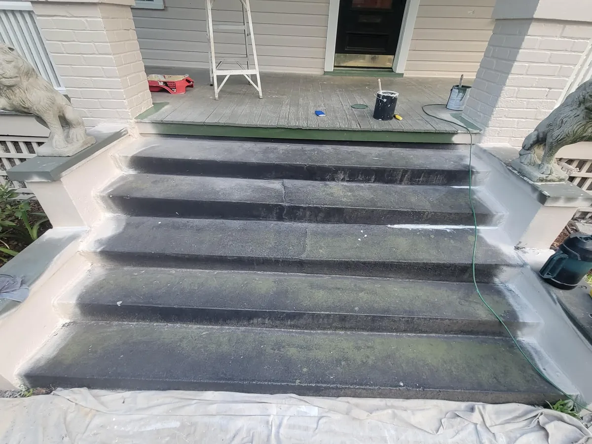 Stained and mildewed concrete porch steps before painting, with prep materials in place